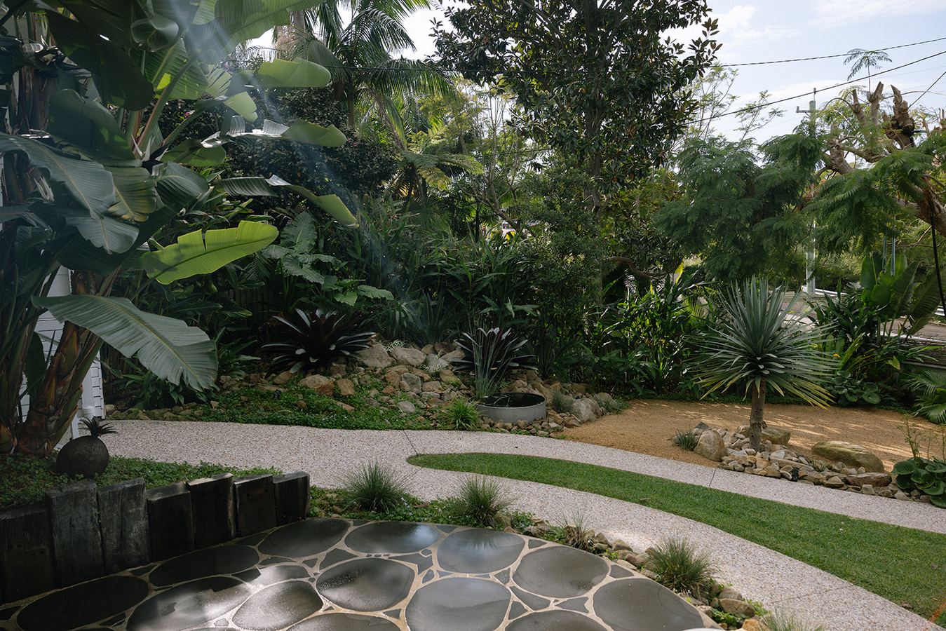 Lush tropical garden with pruned foliage — ongoing garden maintenance Wollongong