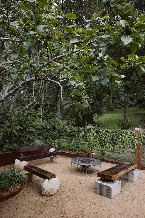 Fire pit and recycled timber benches within a maintained garden — Thirroul NSW