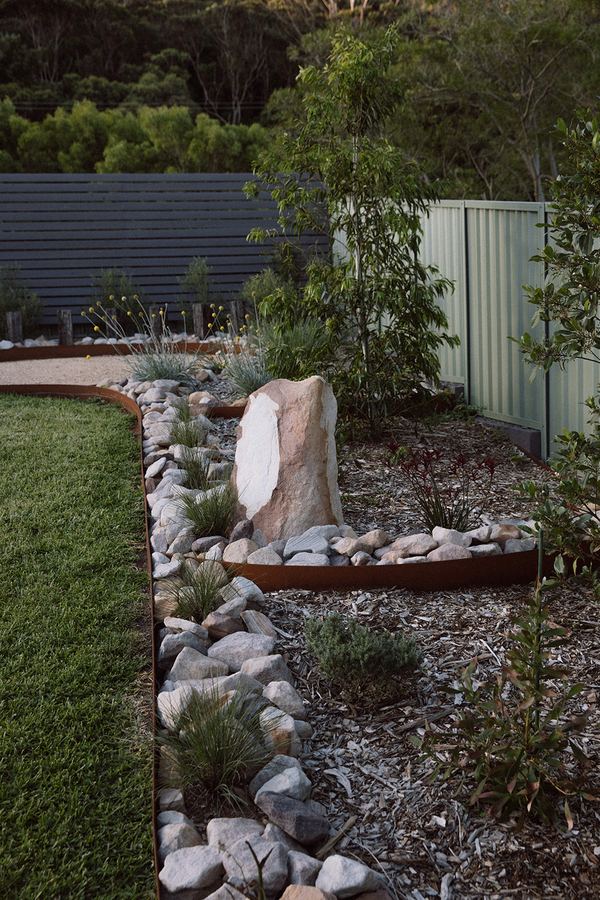 Native garden bed with feature sandstone rock — native garden maintenance NSW coast